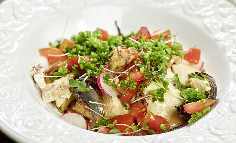 Hendlsalat mit Tomaten und Kräutern im Teller