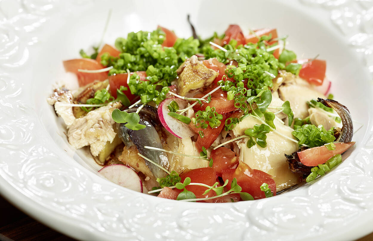 Hendlsalat mit Tomaten und Kräutern im Teller