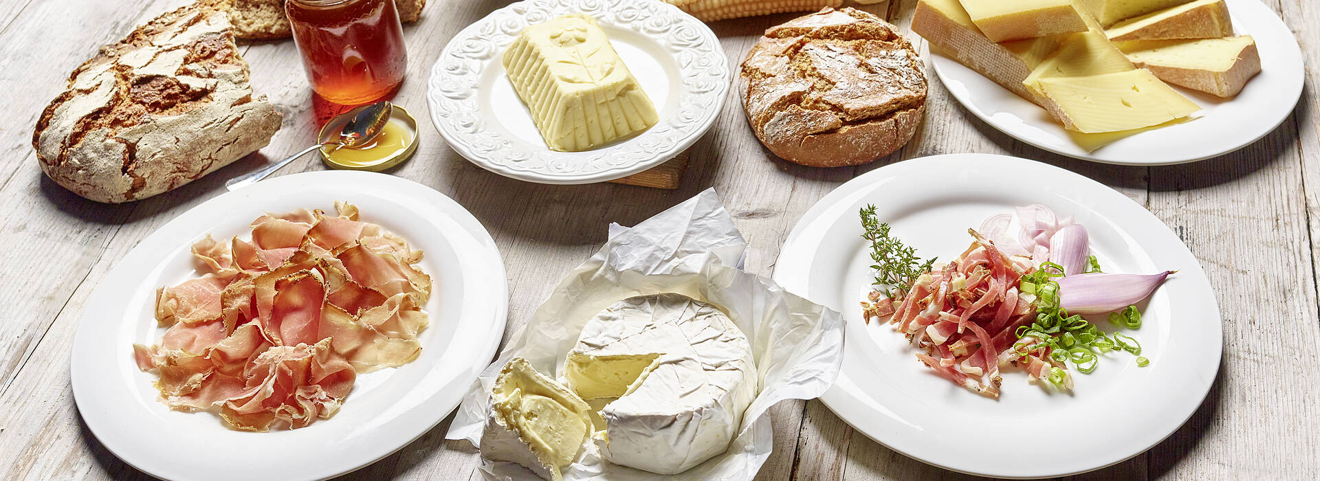 Slow Food in Kärnten am Holztisch mit Schinken Speck Käse Butter Honig
